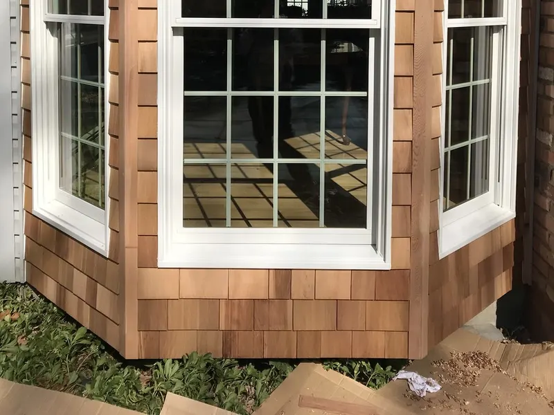 Cedar shingle siding on a bay window bump-out with new white windows