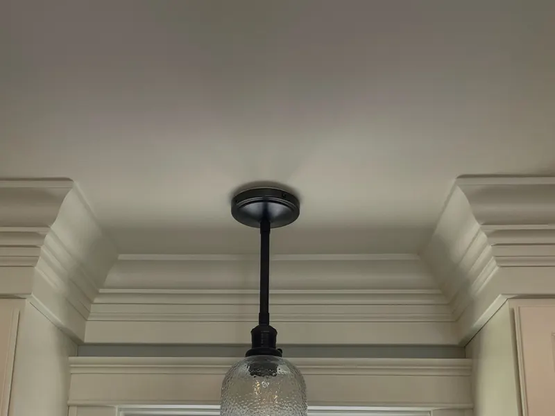 Built-up crown molding and painted window casing around a kitchen window