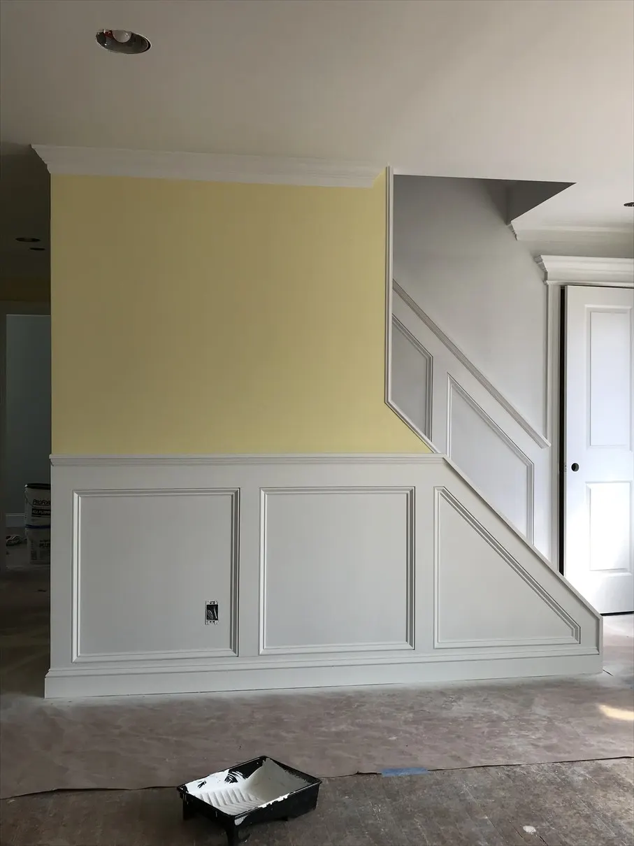 Recessed-panel wainscoting with chair rail and matching stair wainscoting installed by Old Town Renovations in a Long Island home