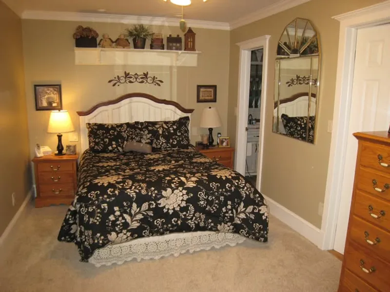 Bedroom with crown molding, a painted wall shelf, and white door casing
